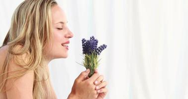 Pretty blonde woman smeling lavender