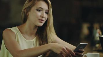 mujer enviando mensajes de texto y tomando café video