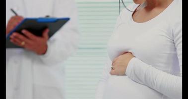 mulher grávida sorridente consultando um médico