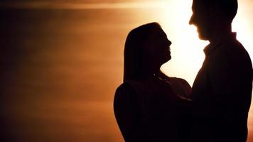 man och kvinna som kysser vid solnedgången video