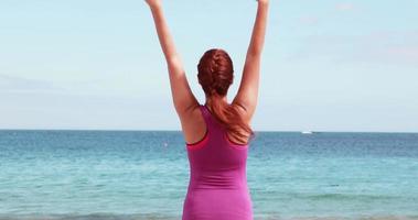 vrouw doet yoga op het strand