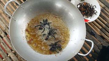 les tarentules sont plongées dans de l'huile bouillante pour la cuisson