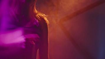 Frau DJ tanzt und spielt Musik im Nachtclub