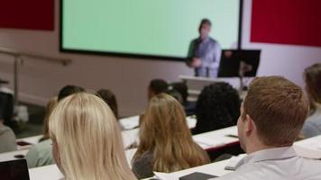 Teacher in lecture theatre presenting to students, rack focus, shot on R3D