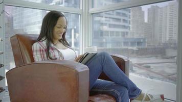 mulher hispânica com um tablet em condomínio em 4k urbano