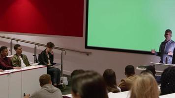Teacher in lecture theatre presenting to students, pan, shot on R3D video