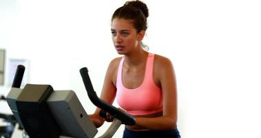 Fit brunette working out on the exercise bike video