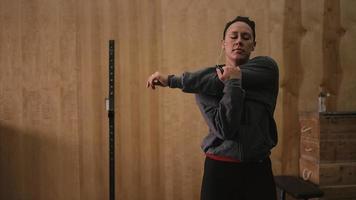 Eine fitte junge Frau streckt ihre Arme vor dem Training im Fitnessstudio aus video