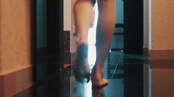 vista da mulher elegantemente andar no banheiro no apartamento. pernas nuas. chão. caminhando video