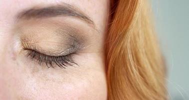 extrem närbild av ett brunt öga av en kvinna med foxyhår