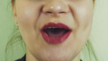 View of woman with red pomade on lips sing in front camera. Mouth. Expression video