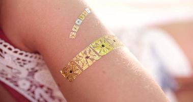 boho flicka med en tillfällig arm tatuering i guldfolie
