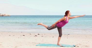 vrouw doet yoga op het strand