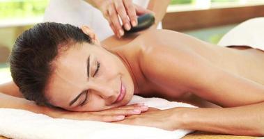 jonge vrouw krijgt een hot stone-massage