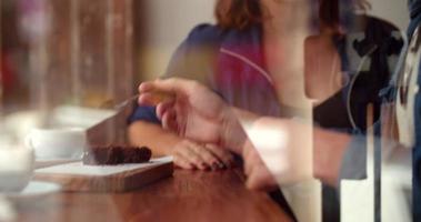 homem alimenta mulher brownie em cafeteria video
