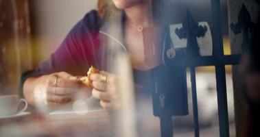 donna hipster mangia croissant nella caffetteria video