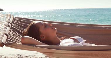 vrouw ontspannen in een hangmat op het strand video