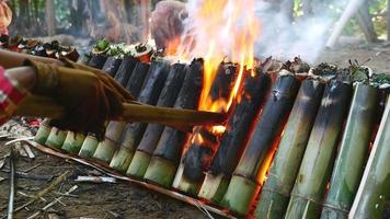 donna girando torte di bambù che cucinano sul fuoco