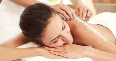 Mulher bonita fazendo massagem esfoliante com sal video