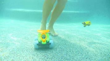 vrouw struikelt over speelgoed dat op de bodem van een zwembad loopt video