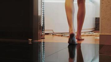 weergave van vrouw lopen elegant naar de badkamer op zijn tenen en gaan zitten op het witte bad video