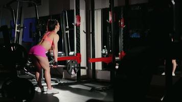motivatie en toewijding aan de sport: atletische vrouw trainen in een sportschool in de schijnwerpers. vrouwelijke bodybuilding