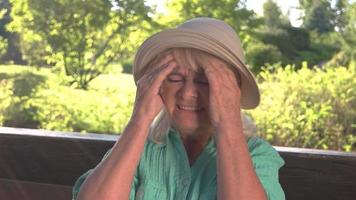 Elderly lady has headache. video