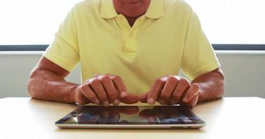 Vue rapprochée de senior man using tablet computer video