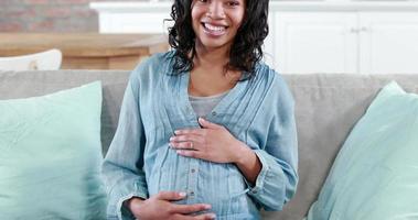 glad gravid kvinna på soffan