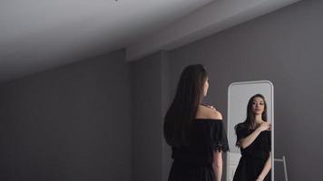 aantrekkelijk donkerbruin meisje dat in spiegel kijkt