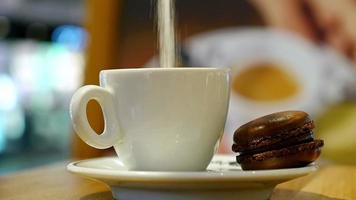 Taza de café con macarrón marrón en un café interior