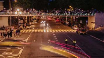 Der Nachtverkehr von Autos und Menschen in der Nähe des Abends zeigt Springbrunnen in Barcelona, Spanien. Zeitraffer video