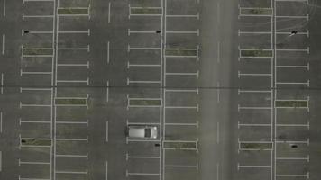 Antena 4k: carro partindo em estacionamento vazio, tarde da noite video