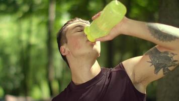 hombre bebiendo agua después del entrenamiento físico. fitness hombre bebiendo agua video