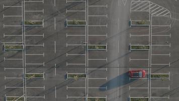4K Aerial: Static Shot, Car Leaves Empty Parking Lot video