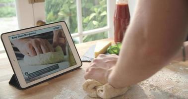 pessoa após receita de pizza usando o app no tablet digital video