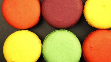TRACKING: Top view of a Rows of Colorful Macaroons on a black table video