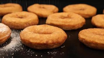 Dolly: Ein Zuckerpulver, das auf einen Donut fällt video