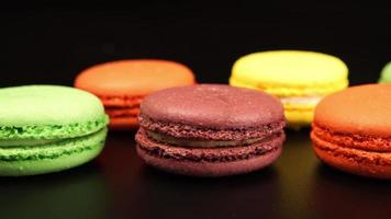 TRACKING: A rows of a colorful macaroons is on the black table