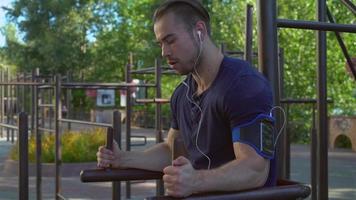 Bodybuilder trains outdoors with mobile application