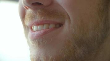 close-up da boca do homem abrindo para sorrir, fechando, vista lateral