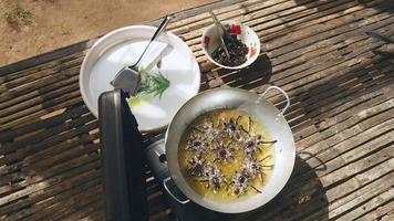 stekt tarantula i wok matlagning med tang