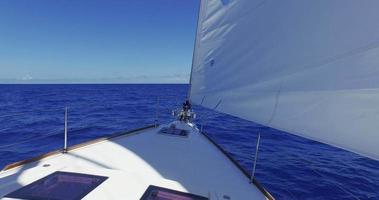 dolly shot van een zeilboot in het midden van een blauwe oceaan
