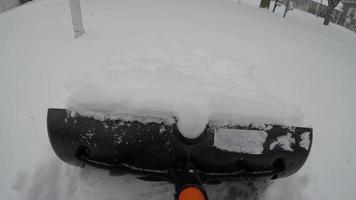 Shoveling fresh snow on Driveway POV from shovel