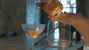 Camarero mezclando un cóctel con cuchara en el bar, 4k video