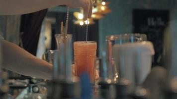 Camarero mezclando un cóctel con cuchara en el bar, 4k
