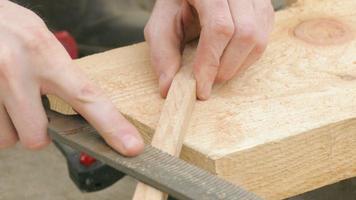 polissage de planche de bois à l'aide d'une râpe
