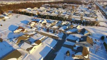 Early morning aerial tour of snow covered neighborhood, suburban homes