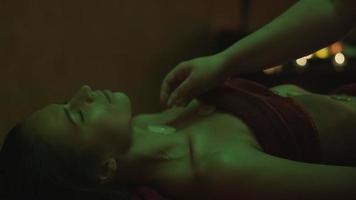 Attraktive junge Frau hat eine entspannende Massage in romantischer Atmosphäre im Spa.