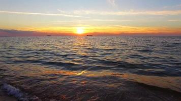 zeegolven spatten tegen de kust bij zonsondergang